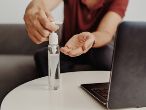 man using hand sanitizer at work