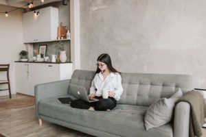 woman sitting on sofa while working